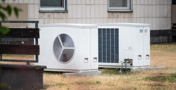 Zwei Wärmepumpen auf einer Wiese eines Mehrfamilienhaus in Düsseldorf, NRW, Deutschland